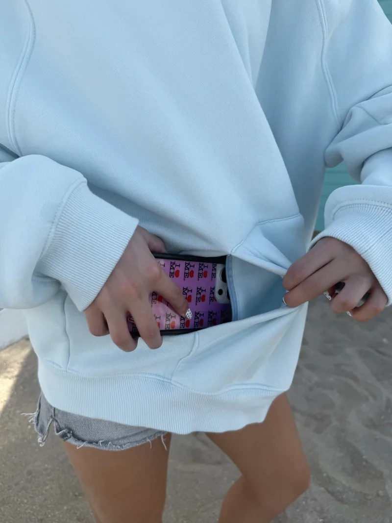 A phone sliding into the zipper pocket inside the front pocket